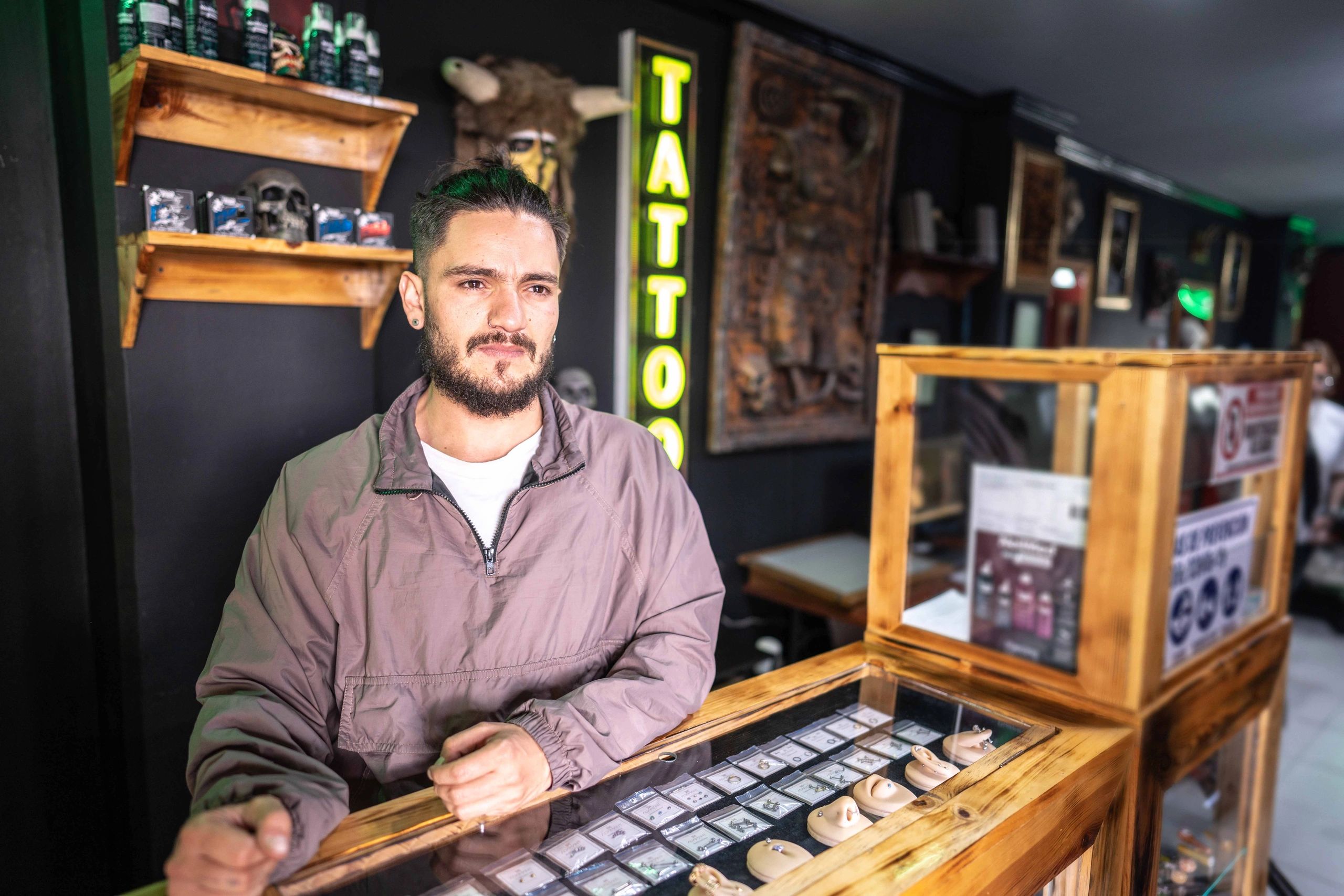 Young man at tattoo parlor counter