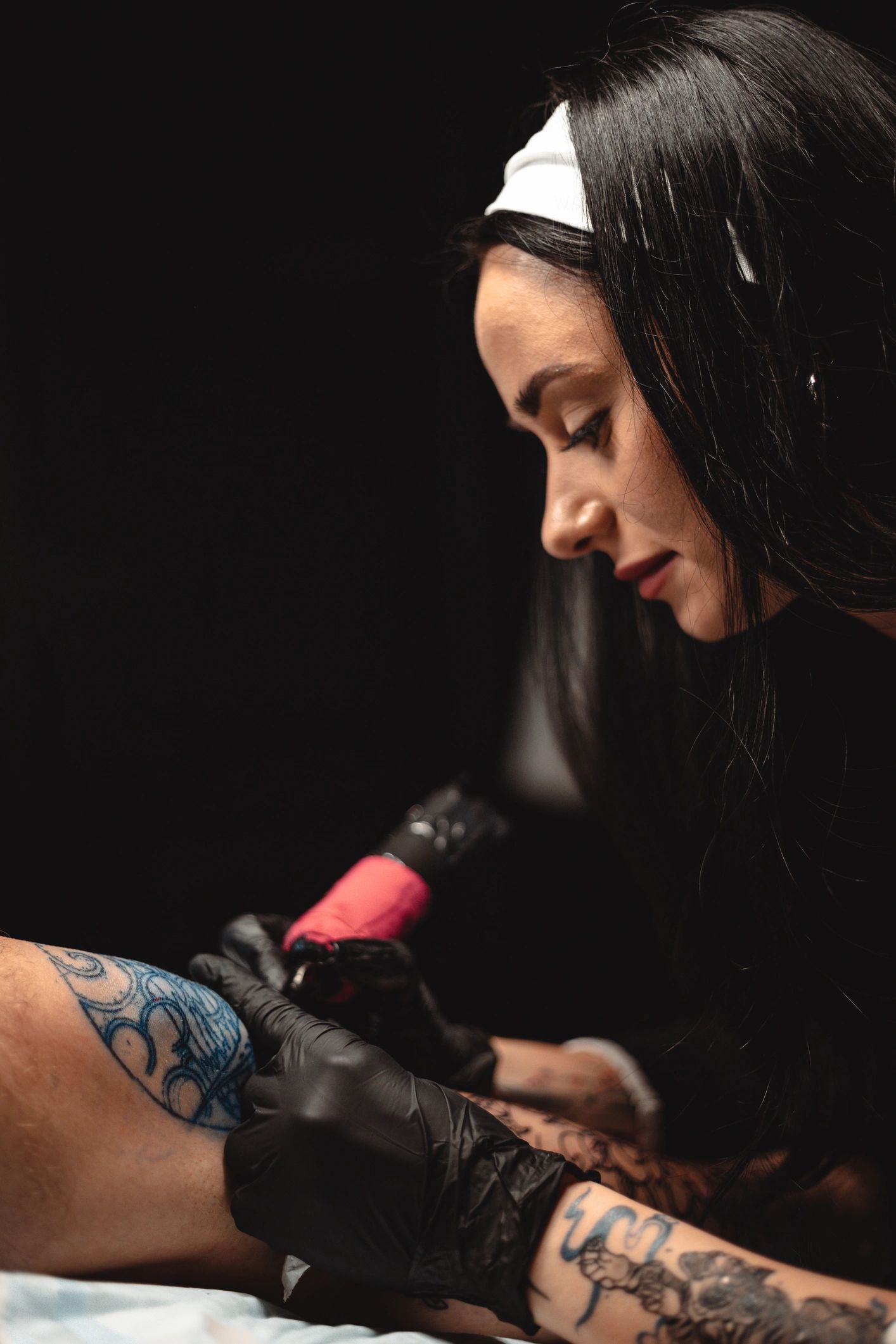 Tattoo artist creating a tattoo under studio lighting